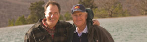 Johnny Morris and Jack Nicklaus pose for a photo on a lake background