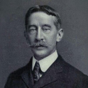 A black and white photograph of George Bird Grinnell wearing a nice suit and posing for the camera.