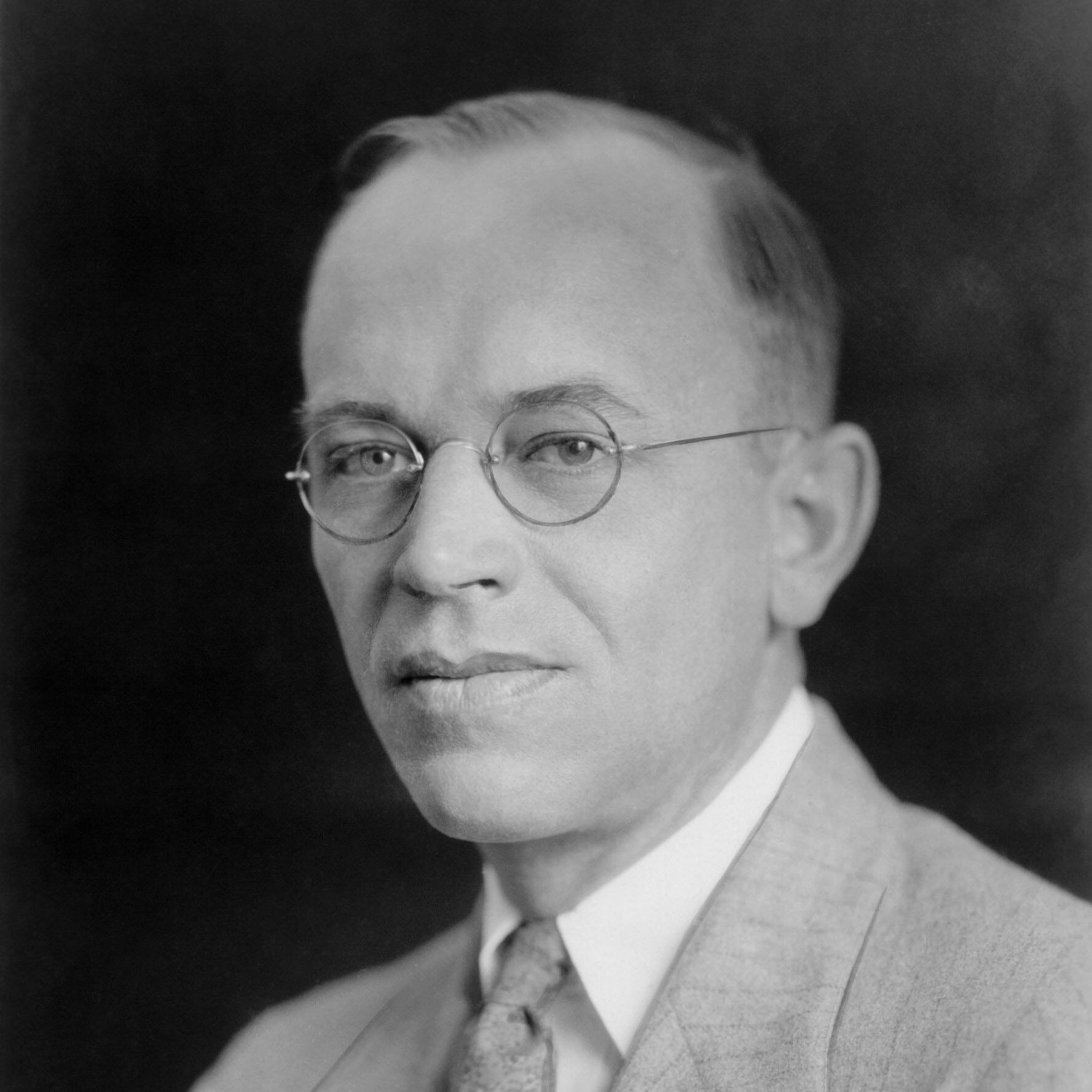 A black and white photograph of Aldo Leopold wearing a suit posing for the camera.