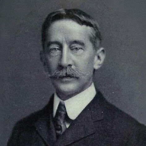A black and white photograph of George Bird Grinnell wearing a nice suit and posing for the camera.